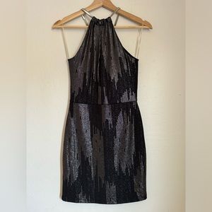 Black mini dress, sleeveless, with silver elastic at the neck, and design size M